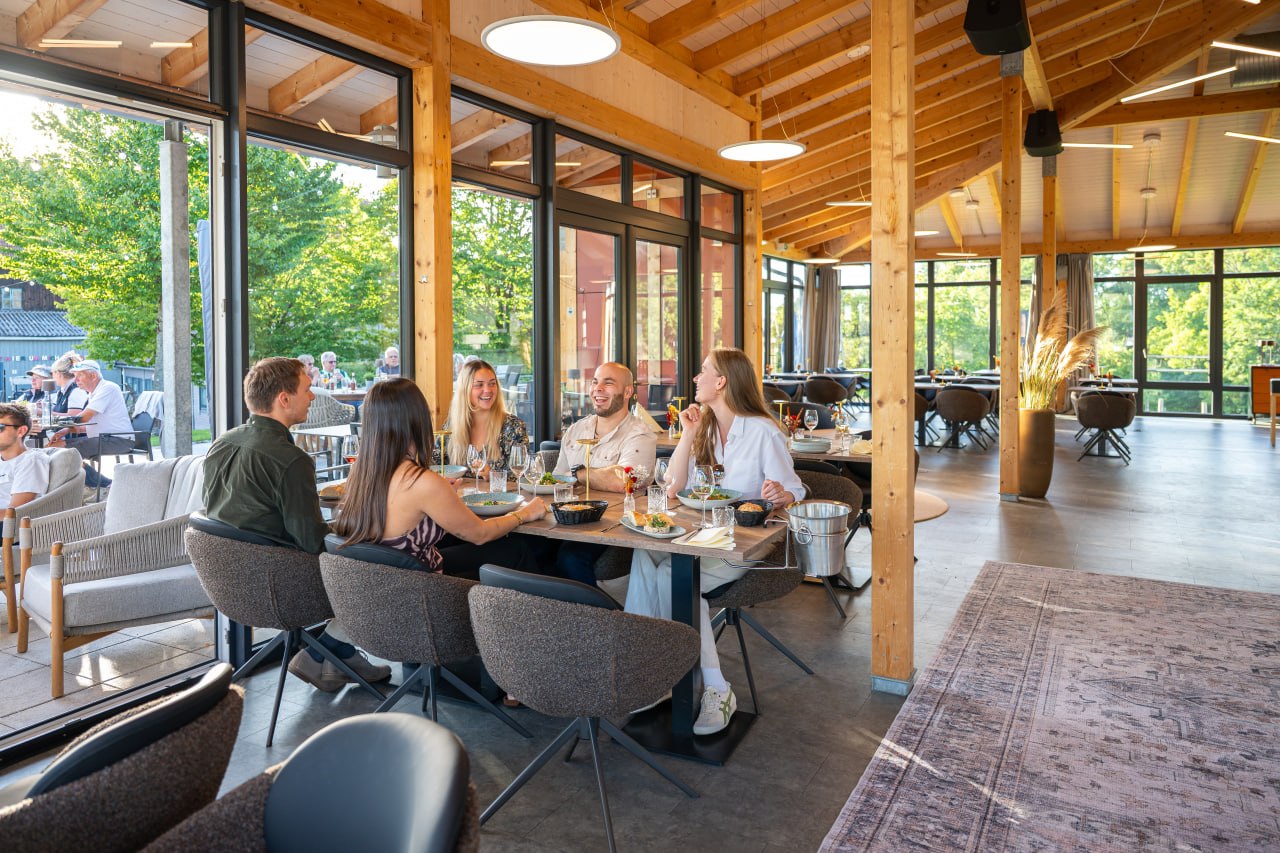 Fünf Gäste genießen gemeinsam Speisen und Getränke an einem gedeckten Tisch im Ludwig.